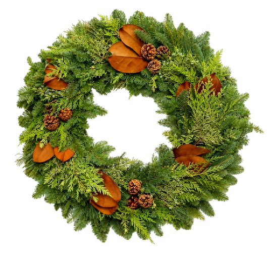 A green evergreen wreath decorated with brown magnolia leaves, pinecones, and small brown acorns, photographed on a plain white background.