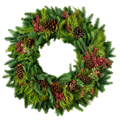 A festive Christmas wreath made of green pine and fir branches, decorated with several brown pinecones and clusters of small red berries, shown on a plain white background.